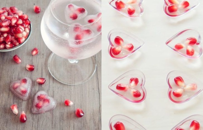 delicious ice hearts with red pomegranate seeds in a glass of water