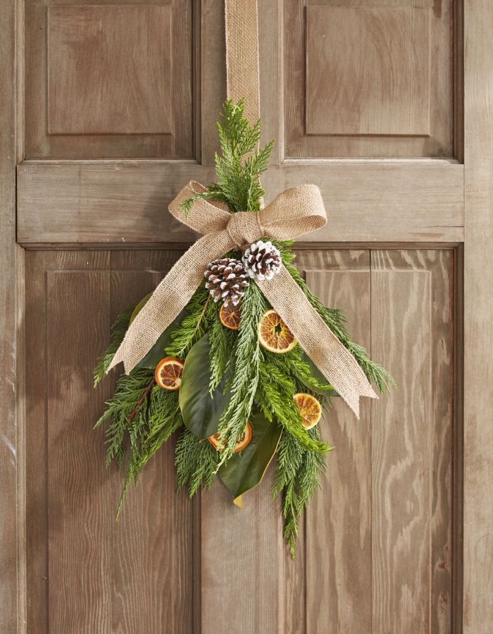 homemade interior decor natural elements bouquet of branches pines and dried orange and a burlap ribbon hanging on a door