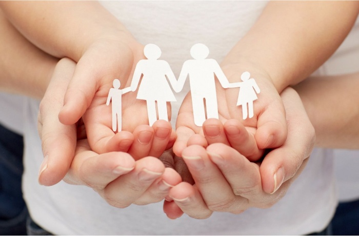 family entity partnership woman and child hands holding silhouette of paper cut family