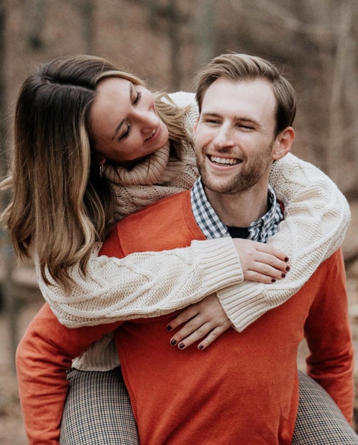 woman hugging a man in an orange sweater couple cuddling