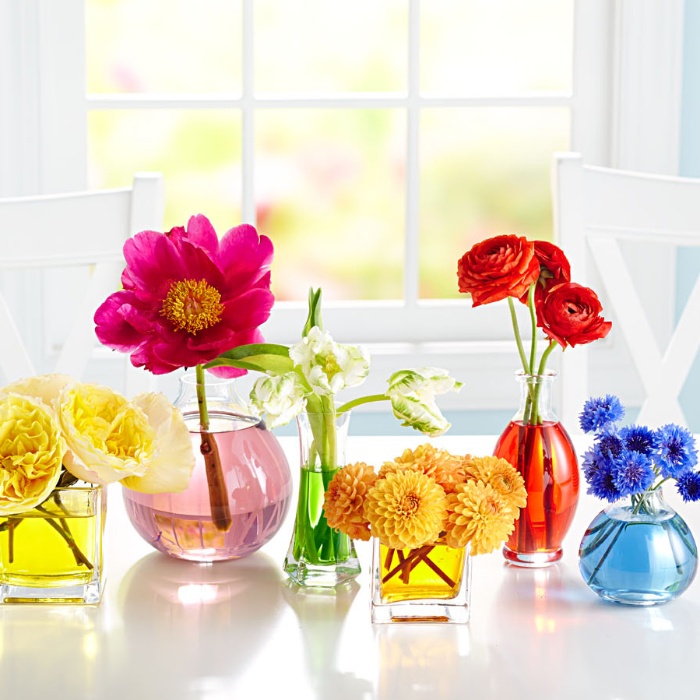 homemade decor colorful flowers in glass jars in a white interior