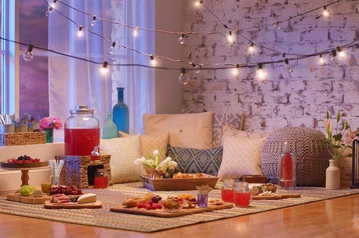 living room picnic with outdoor lights indoor setting with pillows and food