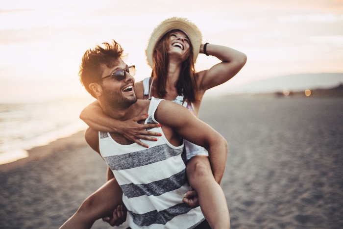 love couple on the beach laughing and having fun