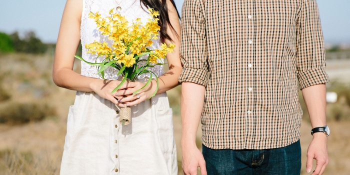 love compatibility couple in the middle of the field woman with white dress holding a bouquet