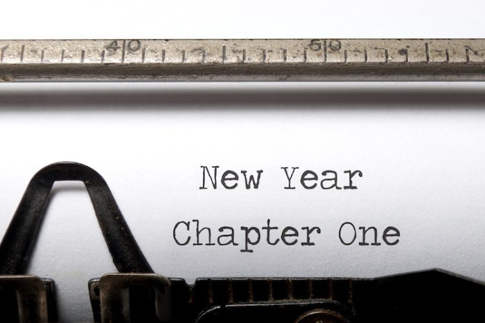 typewriter writing a text on a white paper new year new chapter