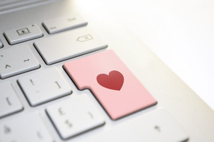 online dating computer keyboard with a red enter button with a heart