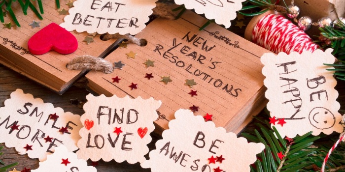 notes with new year resolutions on a table with other christmas and new year decor