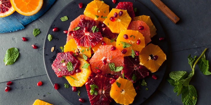 winter fruits different types of oranges on a dark plate with a dressing