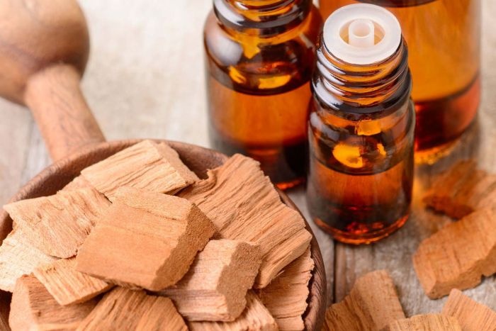 pieces of sandalwood and dark bottles with essential oil