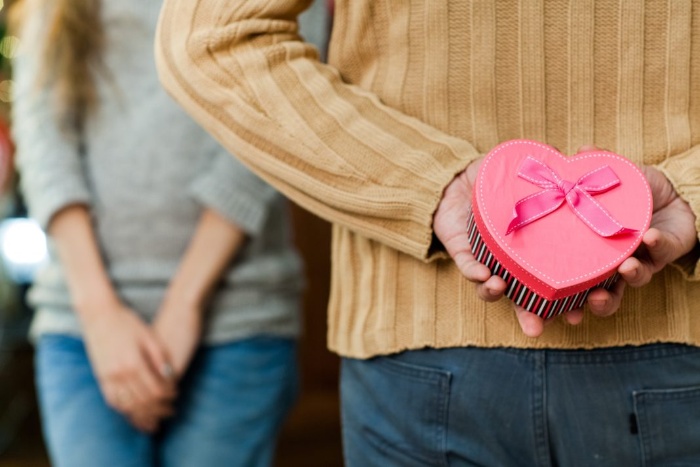 Valentine's day gift man holding a heart gift for a woman