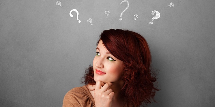 woman with curly hair looking up thinking