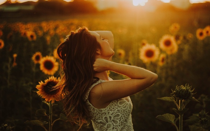 new year resolutions woman in a sunflower field watching the sunrise 