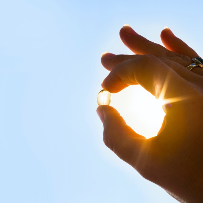 vitamin d hand holding a capsule