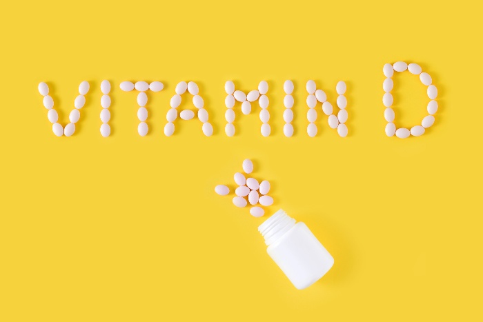 vitamin d pills writing vitamin d on a yellow background