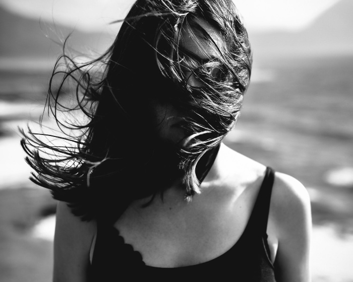 black and white picture of a woman with her hair blown by the wind 