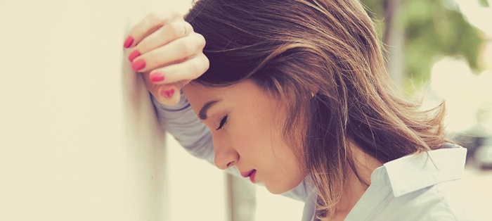 women and burn out new family roles woman bending her forehead on a wall