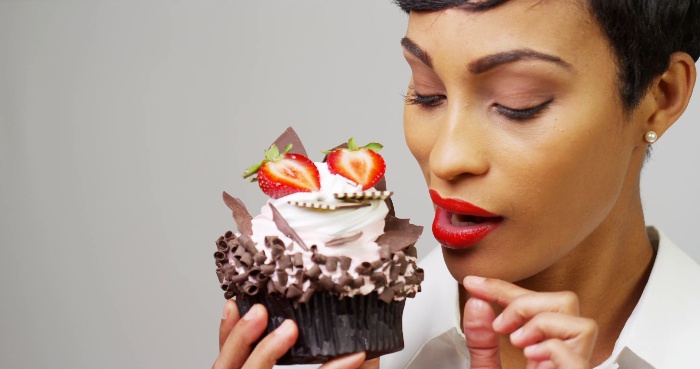 unusual dessert woman with red lipstick holding a dessert with strawberries and chocolate