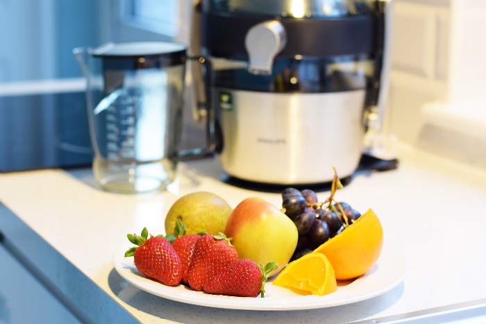 spring juicing challenge a plate with fruits on in a kitchen with a juicer in the background