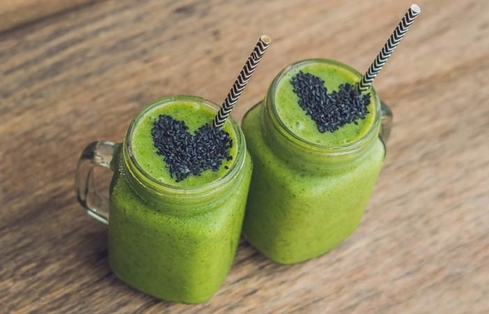 two jars with straws and green vegetable juice with black sesame hearts