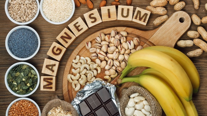 magnesium foods nuts bananas chocolate and other seeds magnesium written on wooden blocks