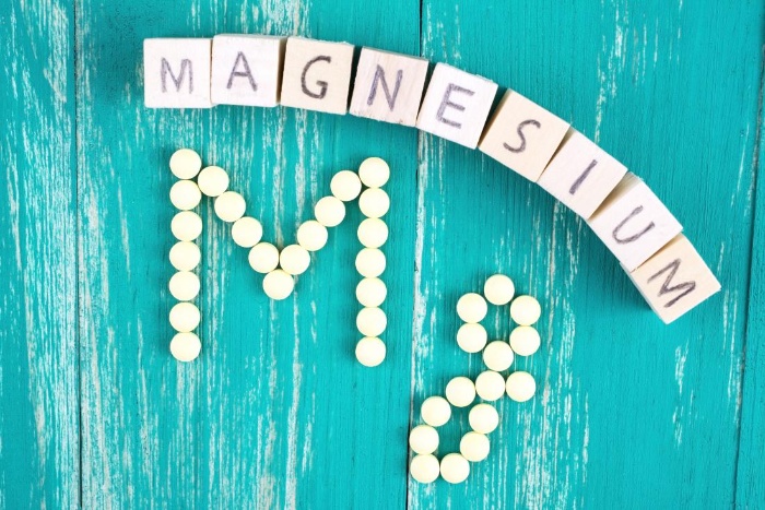 magnesium written with blocks and pills on a light blue background
