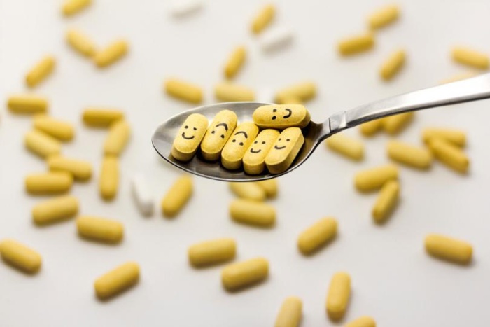 smiling yellow magnesium pills in a spoon