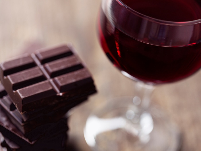 wine and chocolate on a wooden table bars of chocolate and a glass of red wine