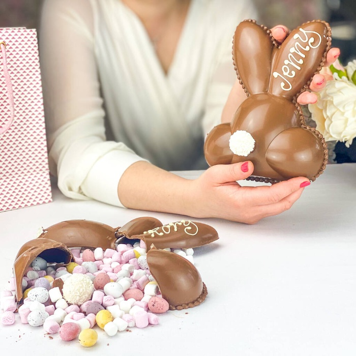 woman holding a hollow easter bunny full of candy 