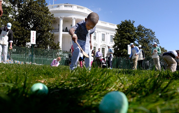 children chasing eggs on the lawn in front of the white house 