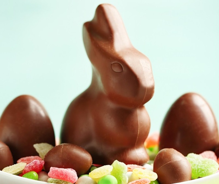 chocolate bunny and eggs on a pile of colorful candy