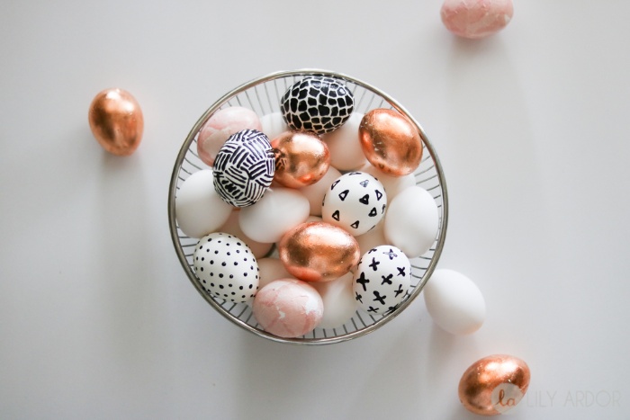 a metal bowl full with modern eggs decorated with metalic and geometrical black and white patterns