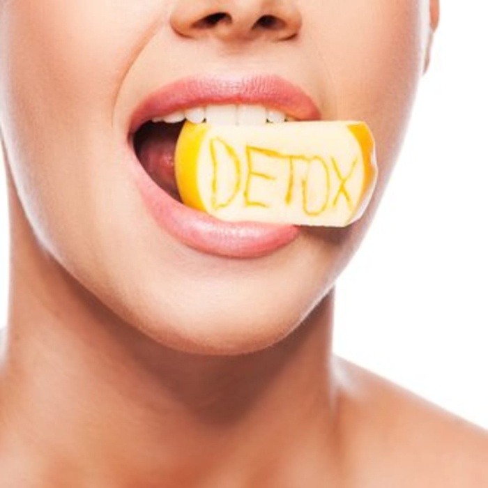 detox lent diet woman with a piece of apple in her mouth saying detox