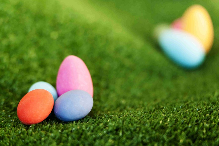 colored easter eggs for easter bowling game on a green lawn