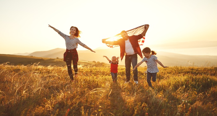 family enjoying time outdoors on a field at sunset