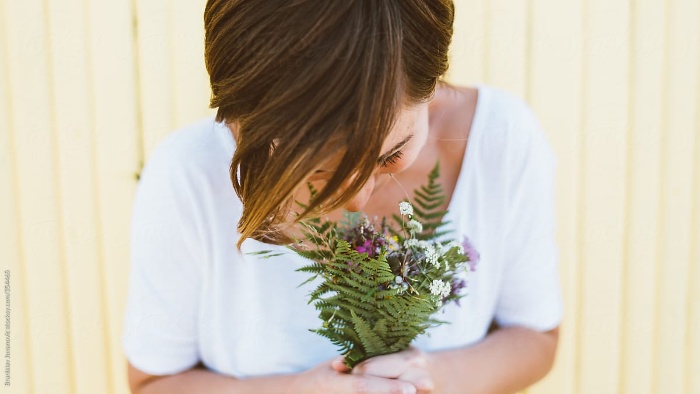 girl in a white dress with short hair holding a wildflower bouquet