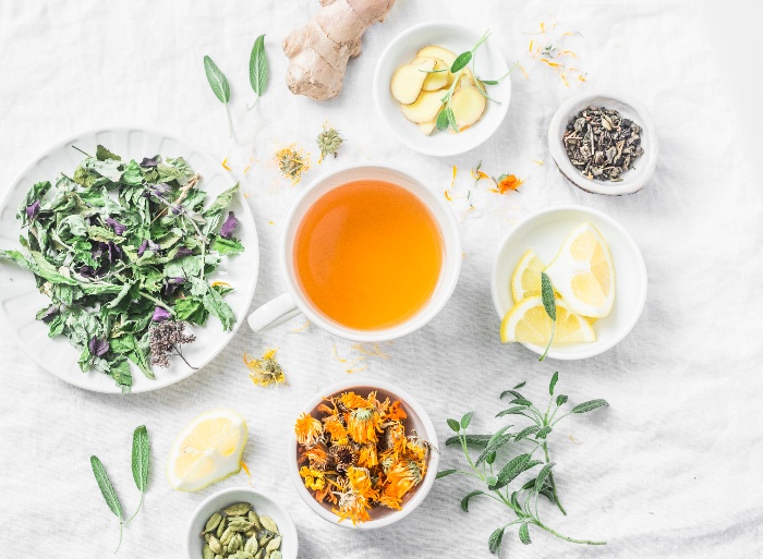 glowing skin liver detox with herbs and teas in white bowls on a table