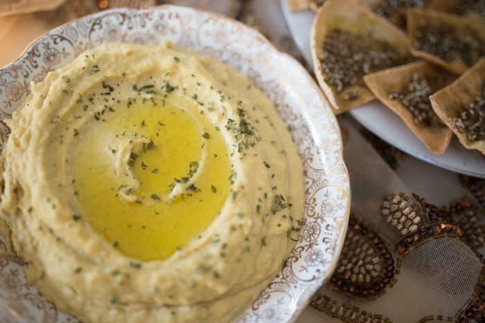 Freshly made hummus with olive oil and herbs on top