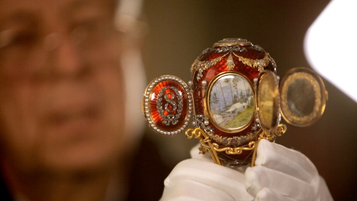 jewel eggs red faberge egg held by a jeweller