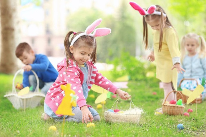 kids dressed like bunnies collecting eggs in baskets