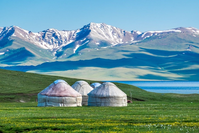 kyrgyzstan landscape with tents mountains green fields and lake