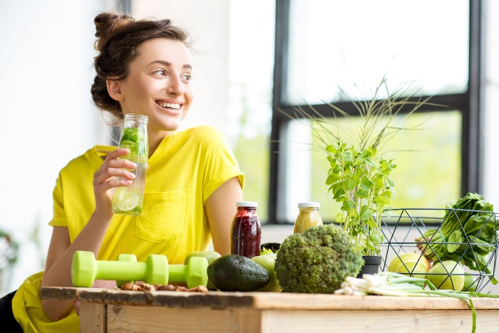 lent girl detoxifying drinking lemon water from a bottle and exercising 