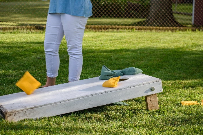 outdoor game tossing bean bags on a green loan 