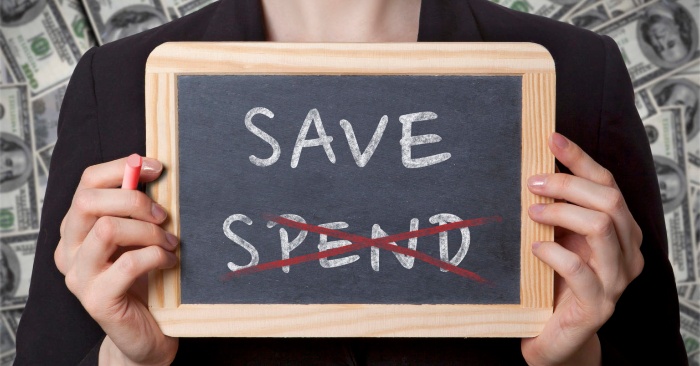 woman dressed in black holding a board where it is written save and spend with a chalk