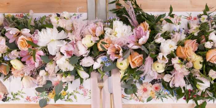 table centerpiece with lots of colorful flowers in the center of the table