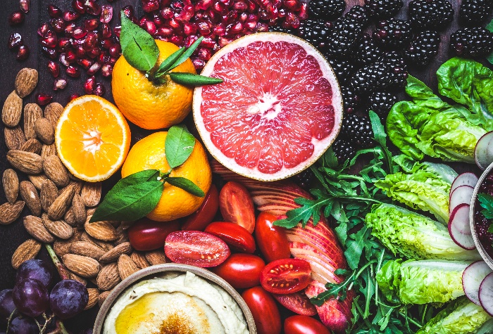 vegetables fruits and almonds close up from above half cut grapefruit and oranges