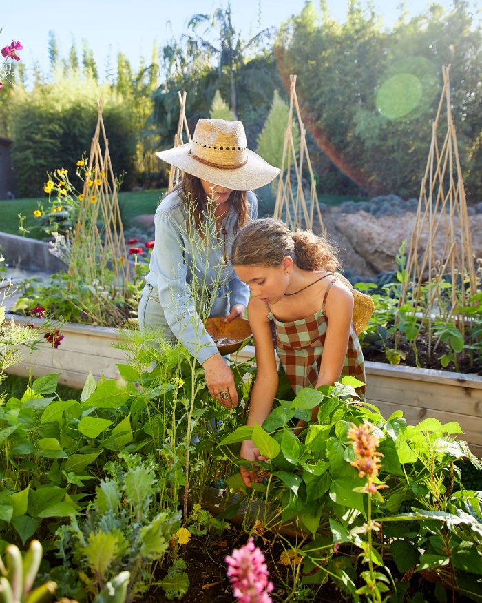 mother and daughter gardening planting out in the garden