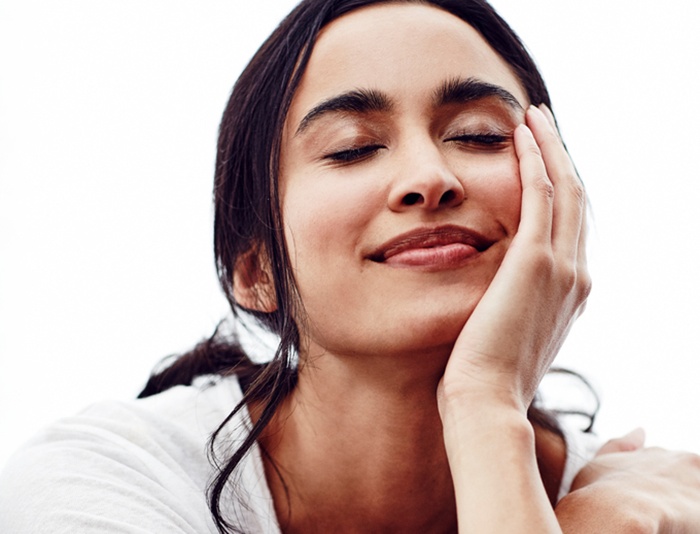 woman holding her face with closed eyes dreaming