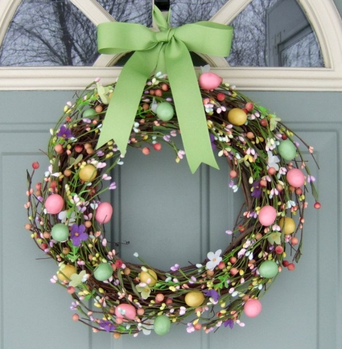 pretty spring wreath with a green ribbon on the outside of a door