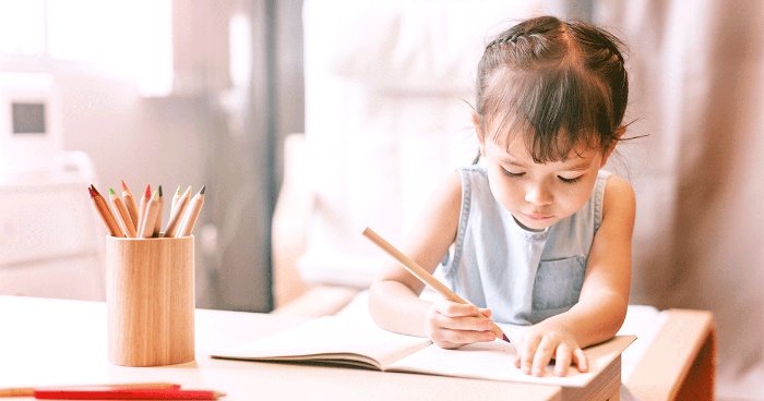 autunomy with kids little girl sititng and writing in a notebook