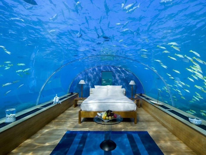 Foji resort underwater bedroom with white bed and lots of fish